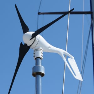 A modern marine wind turbine with carbon fiber blades installed on a sailboat, designed for quiet and efficient power production at anchor.