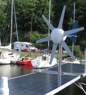 A dual-source renewable energy installation on a yacht featuring both a wind turbine and solar panels for redundant battery charging.