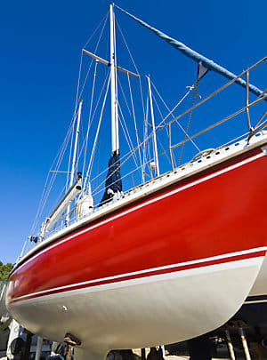 Beautiful restoration of a fiberglass boat hull showing a high-gloss finish after gelcoat repair and polishing