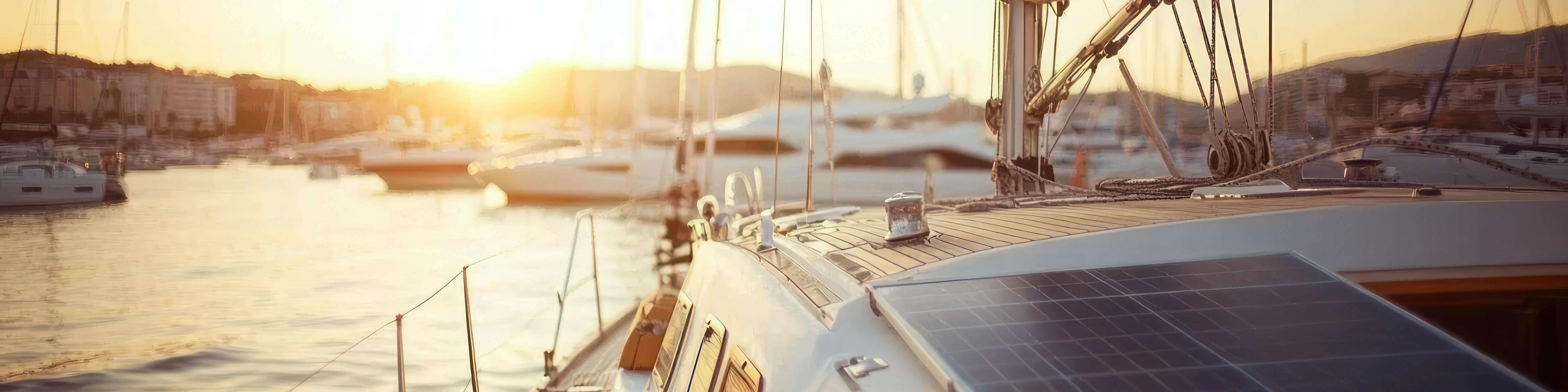 Rigid marine solar panels mounted on a sailboat at sunset.